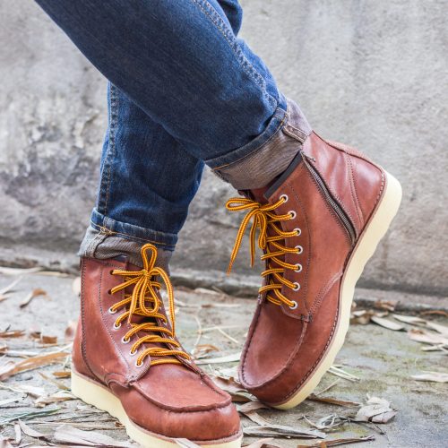 Male foot with brown leather shoes and jeans